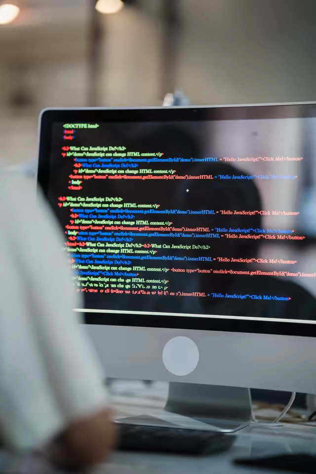 Bildskärm med HTML- och JavaScript-kod i en mörk kodredigerare